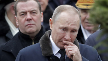 Vladimir Putin cu mâna la nas și cu Evgheni Medvedev