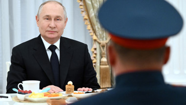 Vladimir Putin bea ceai, mănâncă prăjituri în timp ce zâmbește la un soldat rus