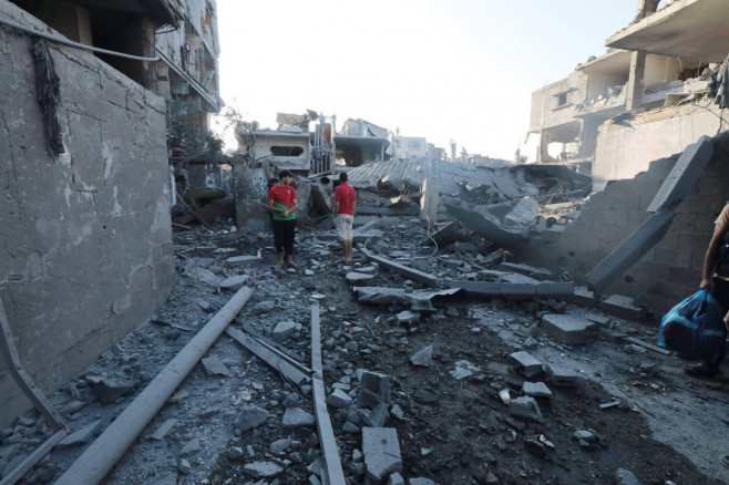 People are seen around destroyed buildings and debris at Dair El_Balah City, after an Israeli airstrikes that has been going on for Nine days in Gaza People are seen around destroyed buildings and debris at Dair El_Balah City, after an Israeli airstrikes