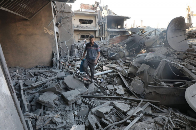 People are seen around destroyed buildings and debris at Dair El_Balah City, after an Israeli airstrikes that has been going on for Nine days in Gaza People are seen around destroyed buildings and debris at Dair El_Balah City, after an Israeli airstrikes