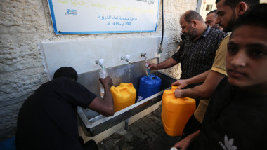 Palestinieni umplu bidoane cu apă în Fâția Gaza