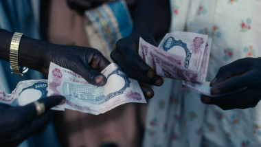NIGERIA West Africa Cropped shot of money paper currency changing hands between two people during transaction