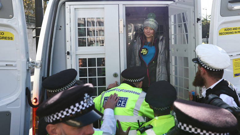 greta thunberg în duba poliției cu polițiști lângă ea