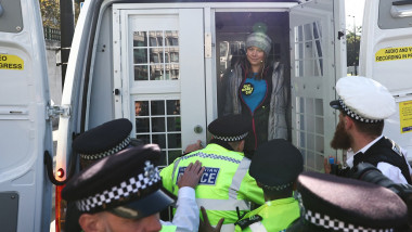 greta thunberg în duba poliției cu polițiști lângă ea