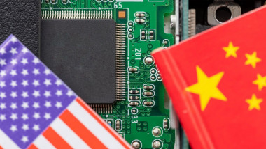 A technology conflict, competition concept with the American and Chinese flags on top of a semiconductor circuit board.