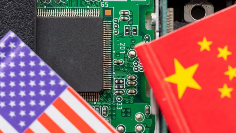 A technology conflict, competition concept with the American and Chinese flags on top of a semiconductor circuit board.