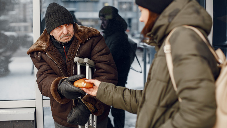 Disabled homeless man on crutches in old clothes