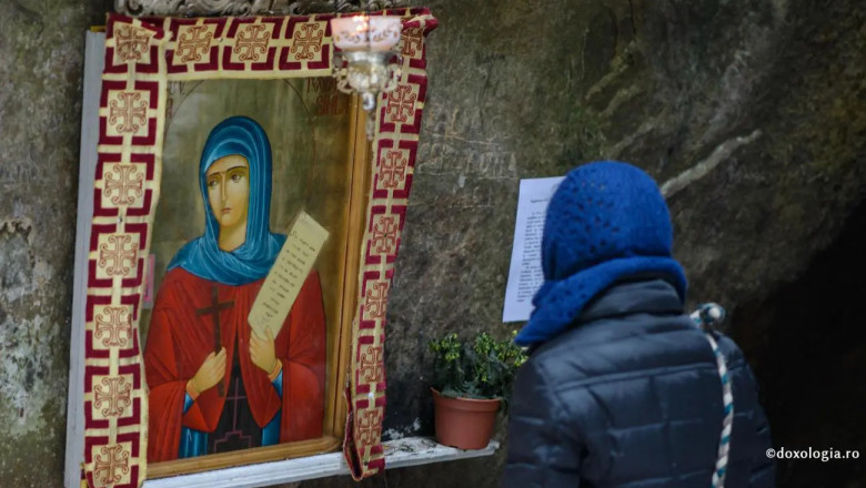 femeie cu spatele se uita la icoana sfanta teodora