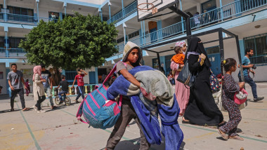 copil cu bagaje și oameni cu bagaje în Gaza