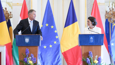Klaus Iohannis și Katalin Novak la pupitre cu steagurile româniei, ungariei și UE în spate