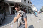 Palestinians walk through debris and destruction littering a street in al-Karama district in Gaza City