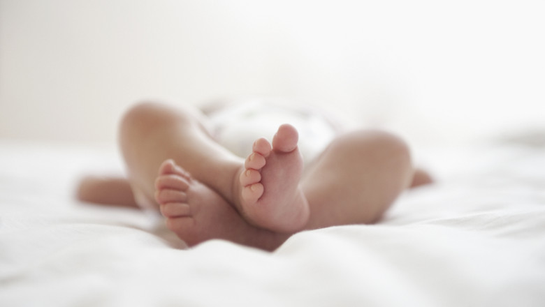 bebelus nou-nascut intins pe pat