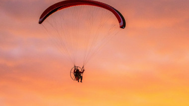 Southport. Merseyside. UK Weather. 18th Sept, 2019. UK Weather; Sunny colourful end to the day as powered hand glider silhouetted in the evening sun, takes a powered flight in light winds as the sun sets in Southport. Paramotor flying machines &amp; Stunt fly