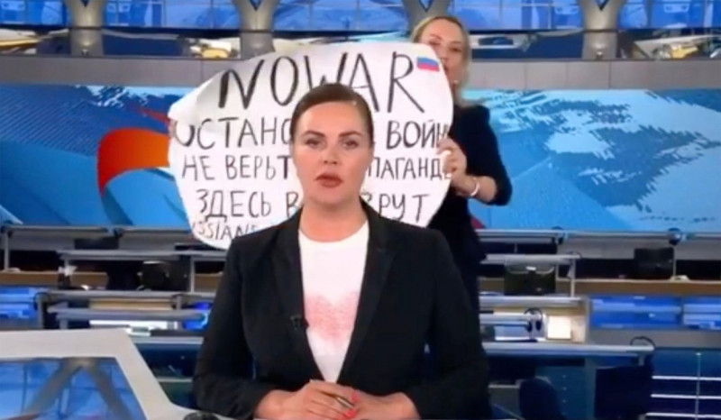 MARINA OCSYANNIKOVA, an editor on Russian Channel One TV programme, protests the war in Ukraine during a news programme on the evening of 14 March 2022. It vreads "No war. Stop the war, Don't believe the propaganda. They lie to you here, Russians agains