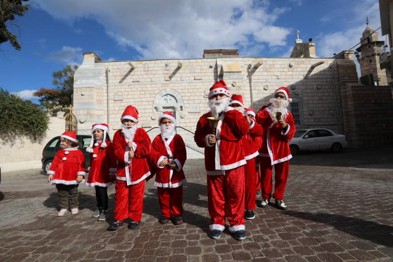 Palestinian Christian children dressed as Santa Claus, walk outside the Church of Saint Porphyrios during Christmas celebrations in Gaza City, Gaza city, Gaza Strip, Palestinian Territory - 23 Dec 2021