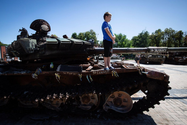 Kyiv, Ukraine. 28th July, 2023. A boy stands on a destroyed Russian tank on display in central Kyiv. Credit: SOPA Images Limited/Alamy Live News