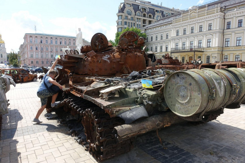 A boy clim on a estroyed Russian army tank are displayed in a square in central Kyiv, Ukraine