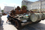 A boy clim on a estroyed Russian army tank are displayed in a square in central Kyiv, Ukraine