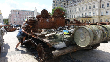A boy clim on a estroyed Russian army tank are displayed in a square in central Kyiv, Ukraine