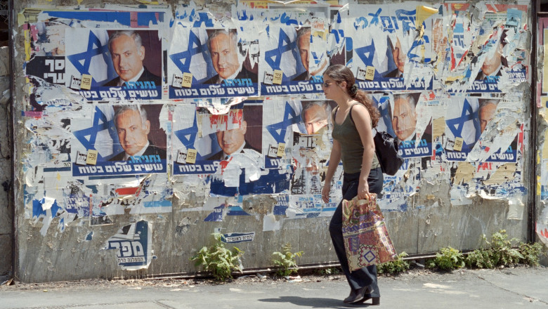 O fată israeliană trece prin fața unor afișe electorale ale liderului opoziției de dreapta Benjamin Netanyahu și a altor sloganuri electorale în Ierusalim.