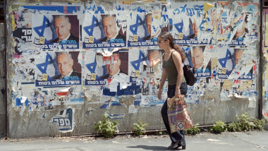 O fată israeliană trece prin fața unor afișe electorale ale liderului opoziției de dreapta Benjamin Netanyahu și a altor sloganuri electorale în Ierusalim.