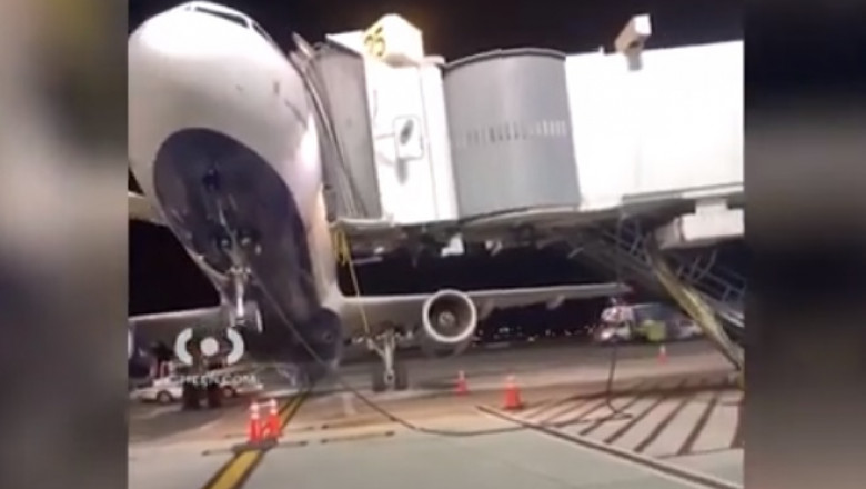 Un avion se ridică pe coadă, în timp ce este descărcat de bagaje pe un aeroport din New York