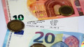 bancnote si monede euro in jurul unui bon fiscal din grecia