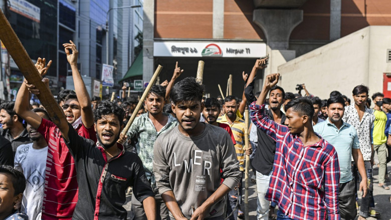 oameni cu bâte dau din mâini și amenință la un protest