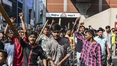 oameni cu bâte dau din mâini și amenință la un protest