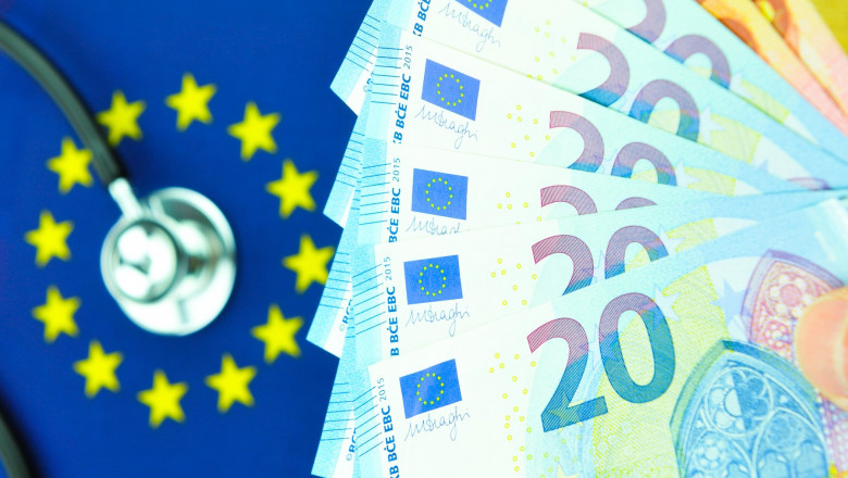 bancnote de 20 de euro cu un steag al uniuniii europene pe fundal si un stetoscop