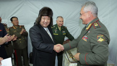 Kim Jong Un, cu o căciulă pe cap, dă mâna cu Serghei Șoigu