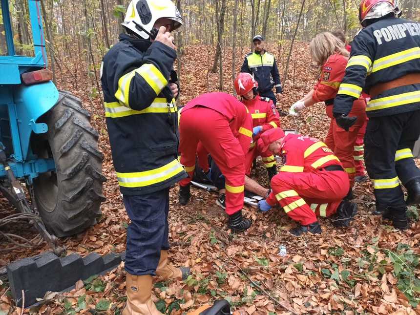Tată și fiu, prinși sub un tractor cu lemne care s-a răsturnat peste ei, într-o pădure din Neamț