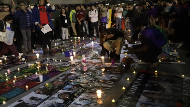 oameni cu poze și lumânări pe asfalt la un priveghi public în mexico city