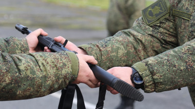 militar înmânează unui recrut din armata rusă noua armă de asalt Ak-12