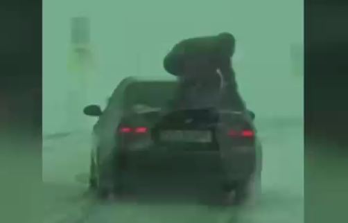 VIDEO. Cod roșu de inconștiență pe șosele: Însoțitorul unui șofer sare pe portbagajul mașinii ca să imprime mai multă aderență