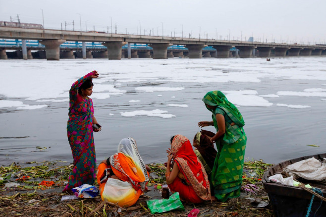 Hindu devotees perform rituals amid the polluted waters of the river Yamuna covered with a layer of toxic foam during the 10-day long Ganesh Chaturthi festival in New Delhi. The Ganesh Chaturthi is a Hindu festival to commemorate the birth of the Hindu go