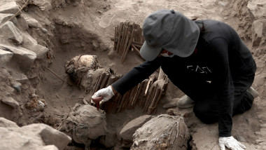 An archaeologist works with mummies found in a pre-Hispanic pyramid in Lima, Peru