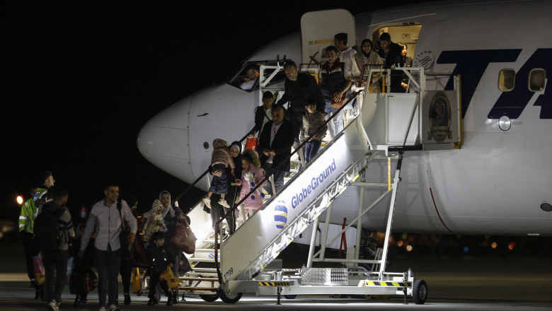 cetateni romani refugiati din fasia gaza care coboara din avion pe aeroportul otopeni