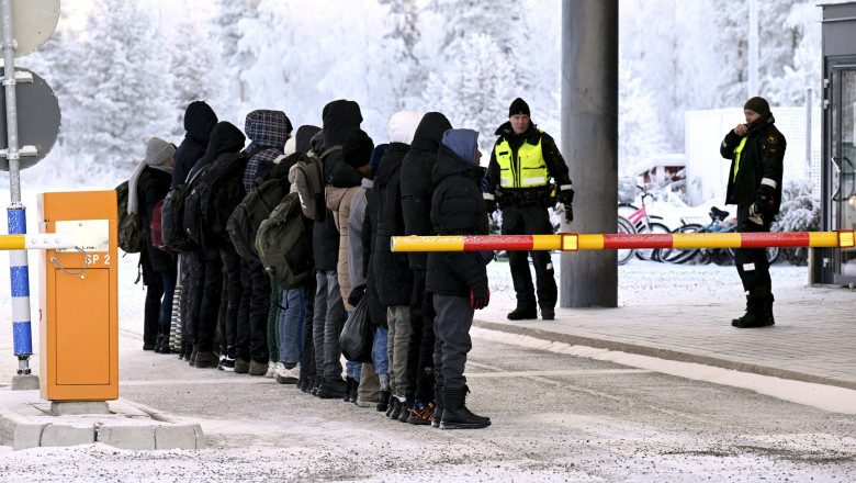 Migranți adunați în linie la un punct de frontieră de la granița ruso-finlandeză