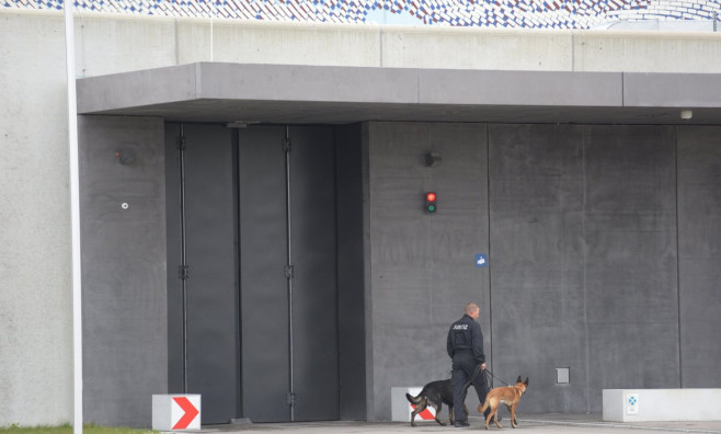 Gablingen, Germany. 30th Oct, 2018. A member of the judiciary walks with two dogs in front of the Augsburg-Gablingen prison. The former Audi Chairman of the Board of Management, Stadler, was detained here on remand. Credit: Stefan Puchner/dpa/Alamy Live N