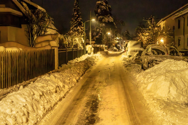 Eisglatte verschneite Nebenstraße in München-Waldperlach abends, 4. Dezember 2023 Deutschland, München, 4. Dezember 2023