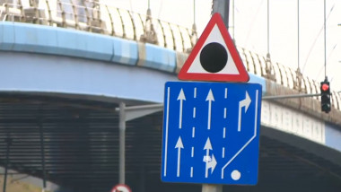 Indicatorul rutier de avertizare „Zonă cu risc ridicat de accidente” deasupra unui indicator de orientare „Selectarea circulației pe direcții de mers în apropierea intersecției”