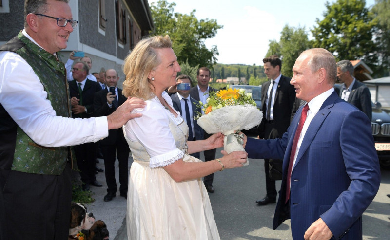 Gamlitz, Austria. 18 August 2018. Russian President Vladimir Putin presents flowers to the bride, Austrian Foreign Minister Karin Kneissl as the groom, businessman Wolfgang Meilinger, left, looks on August 18, 2018 in Gamlitz, Austria. Putin attended the