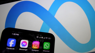 ecranul unui telefon cu aplicatiile facebook messenger instagram si whastsapp cu logoul companiei meta pe fundal