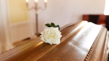 white rose flower on wooden coffin in church