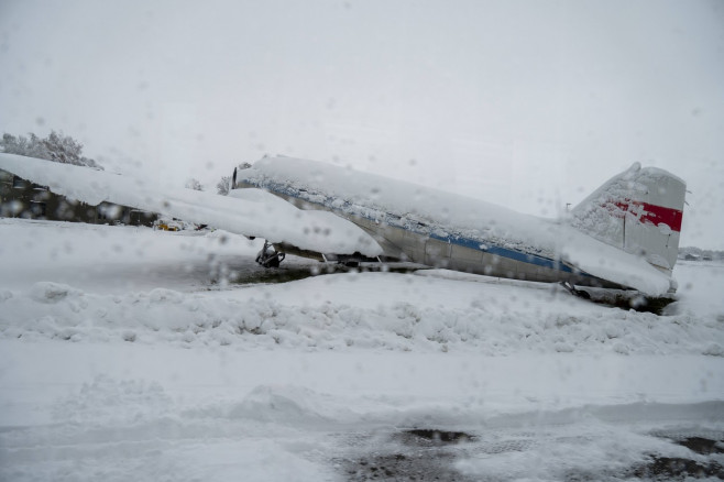 FMM, Bavaria, Germany - December 2, 2023: Onset of winter and snow chaos at the airport in Bavaria, A snowed-in airplane