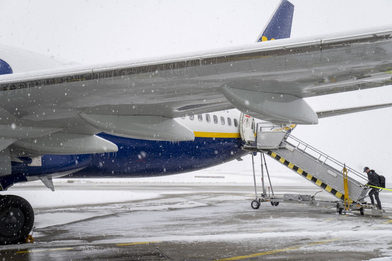 FMM, Bavaria, Germany - December 2, 2023: Onset of winter and snow chaos at the airport in Bavaria, Ryanair aircraft ful