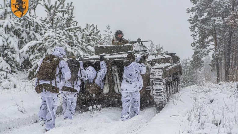 soldati ucraineni pe front in spatele unui blindat
