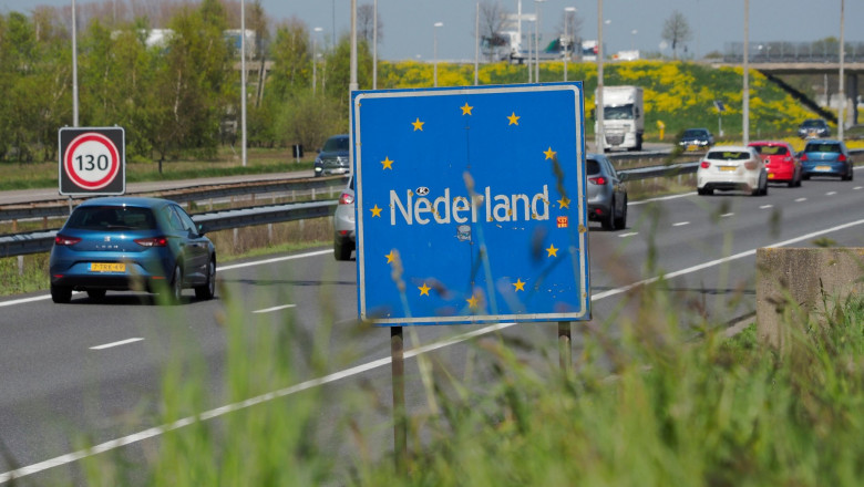 Crossing the border at Hazeldonk, cars driving into the Netherlands with Nederland sign amd 130 kmh speed limit
