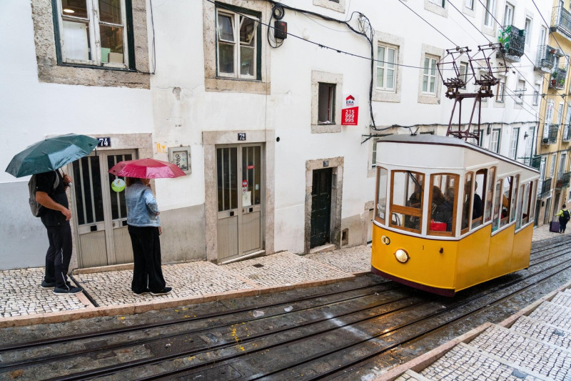 During a torrential rainstorm tourists fill the famous Bica - Lg. Calhariz hill tram in Lisbon, Portugal.